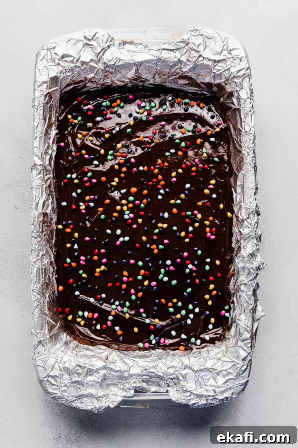 Stardust Brownies 15 Baked Cosmic Brownies in a baking dish, topped with set chocolate ganache and sprinkled with colorful rainbow chips.