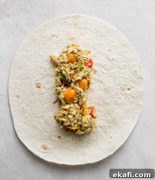 Creamy Avocado Chicken Wraps 7 A flour tortilla filled with the creamy avocado chicken mixture, ready to be rolled.