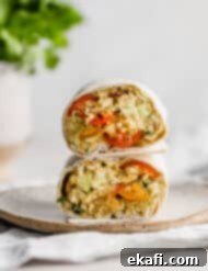 Creamy Avocado Chicken Wraps 10 An Avocado Chicken Wrap cut in half, with the halves stacked on top of one another.