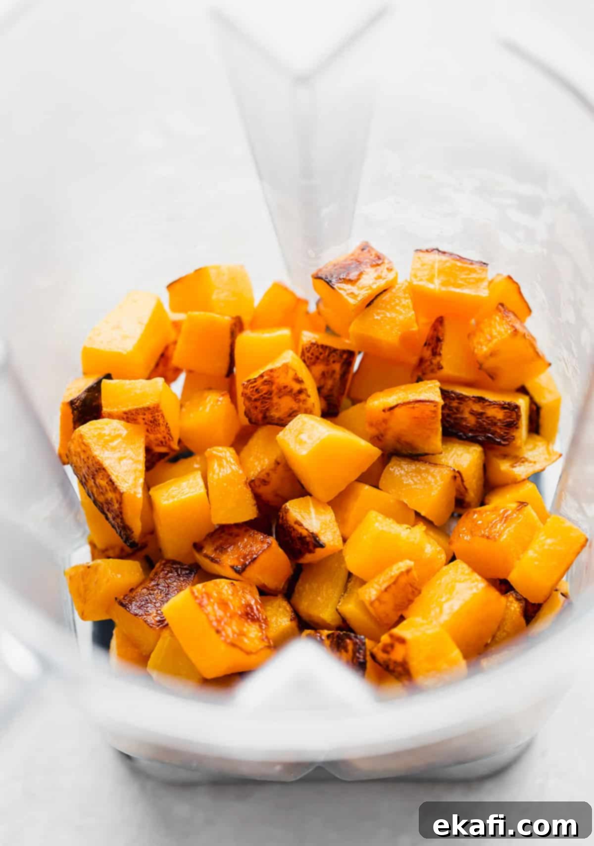 Velvety Butternut Squash Pasta 4 Roasted butternut squash cubes in a blender, ready to be pureed into a creamy sauce. The squash is golden brown and tender, indicating perfect roasting.