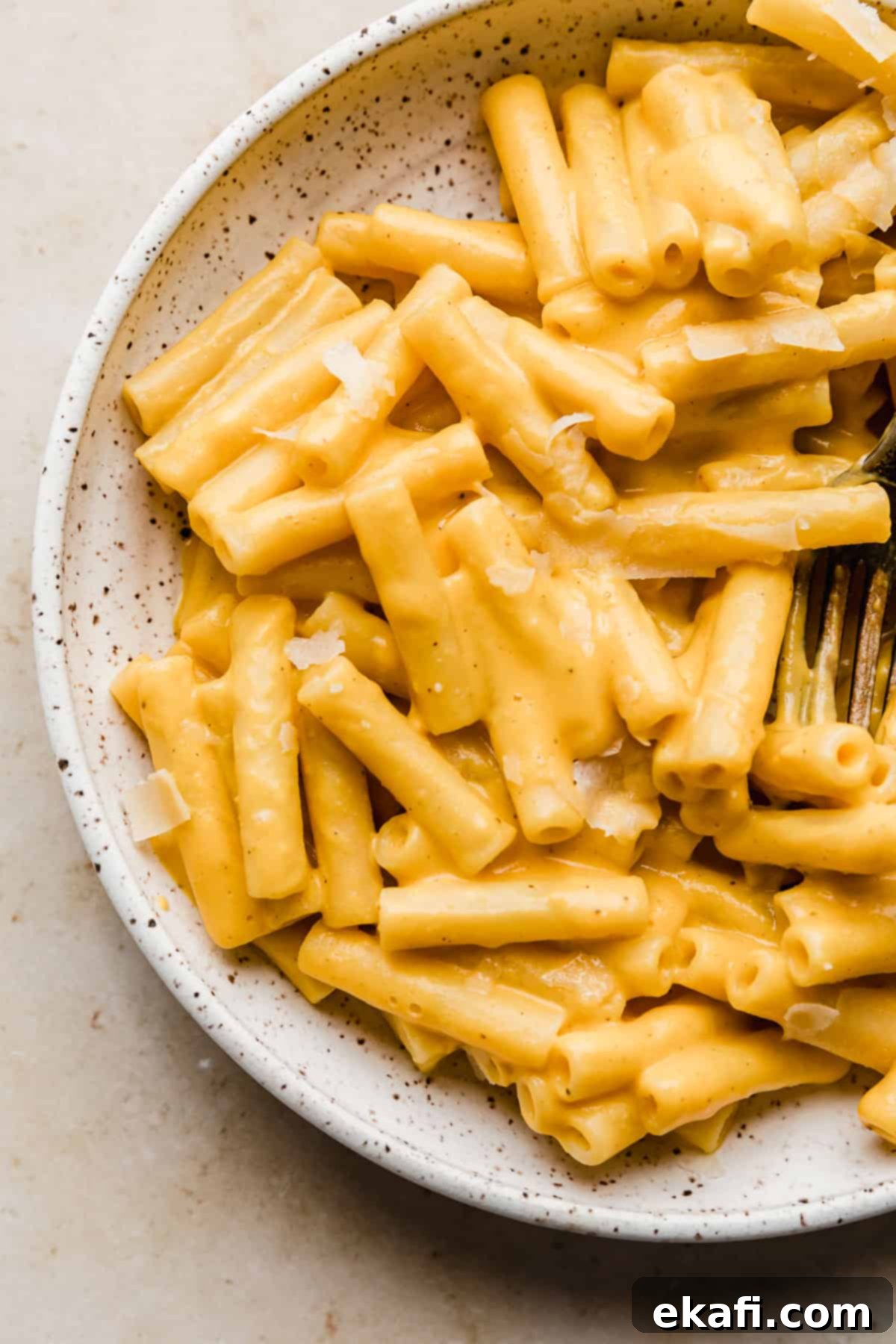 Velvety Butternut Squash Pasta 7 Creamy Roasted Butternut Squash Pasta sauce over ziti noodles in a white bowl, garnished with fresh herbs, ready to be enjoyed.