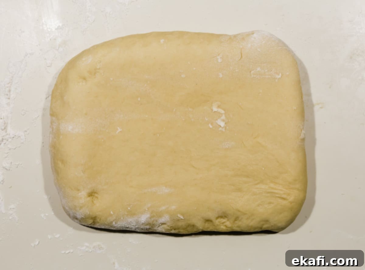 Pillowy Flaky Brioche 9 A sealed rectangle of brioche bread dough on a white countertop after the first butter enclosure.