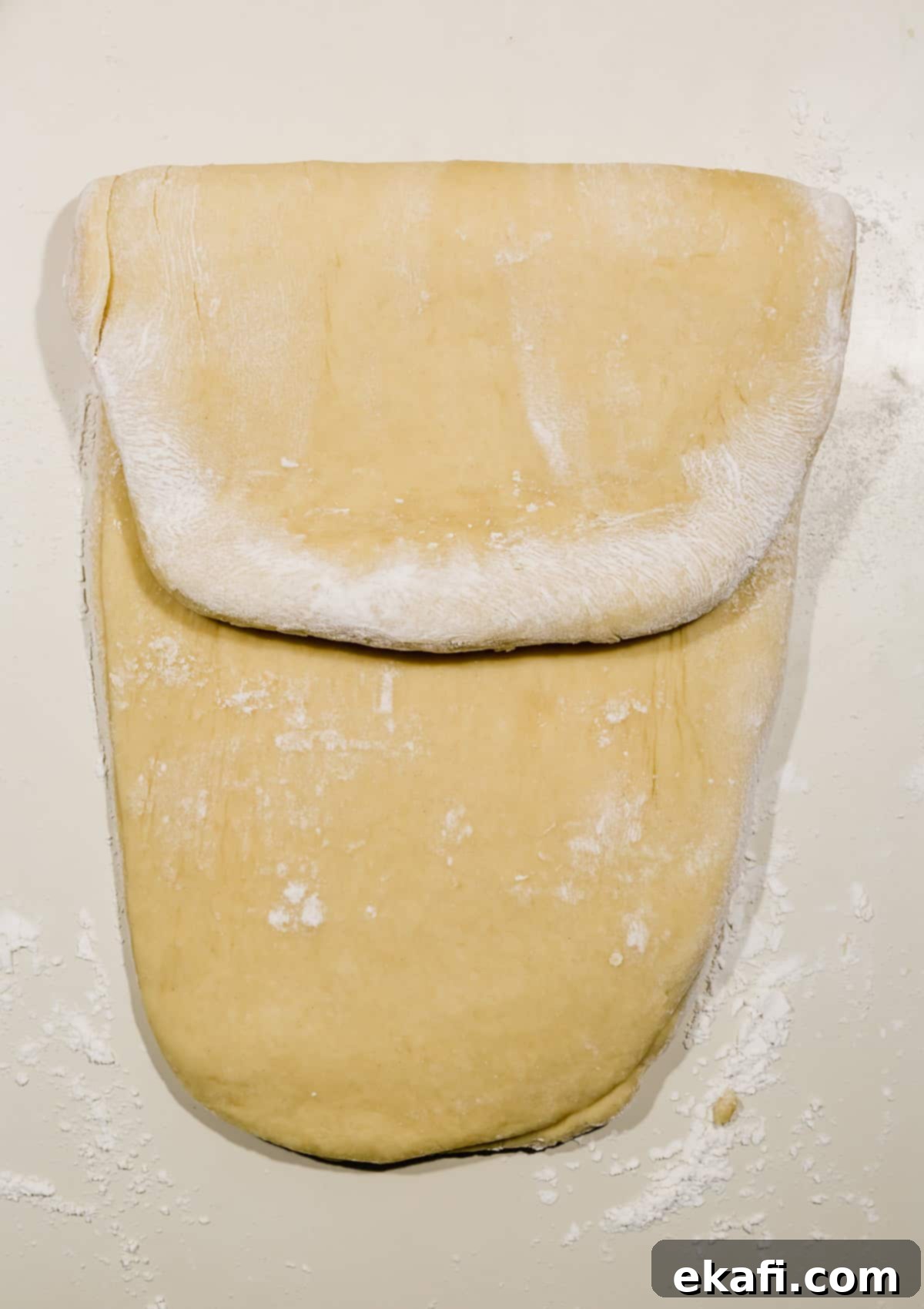 Pillowy Flaky Brioche 10 Brioche dough rolled into a rectangle with the top third folded over, ready for the classic 'business letter' fold.
