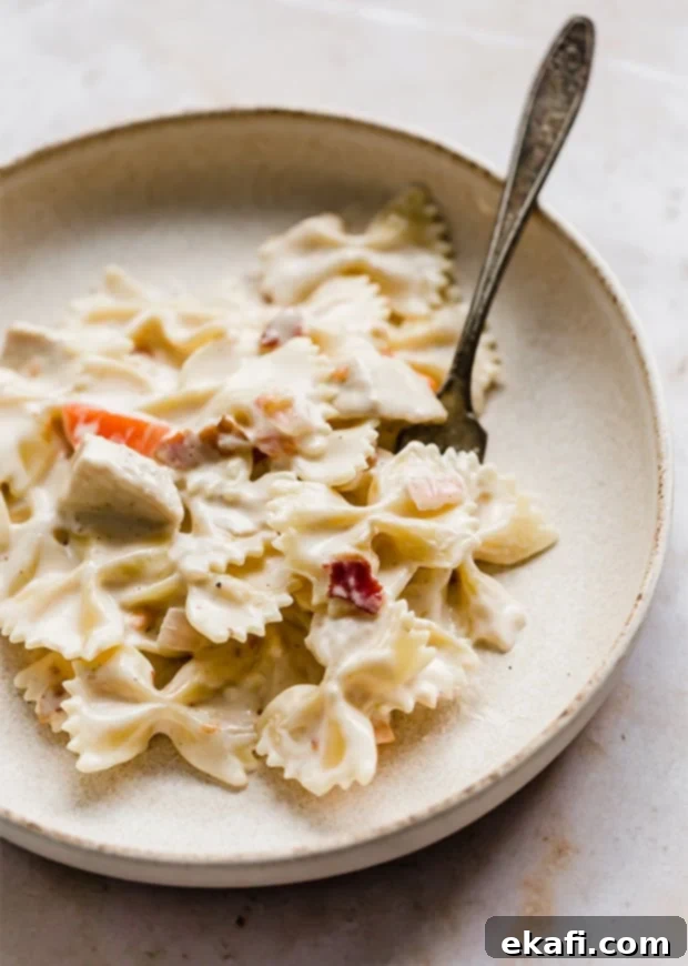 Happy Tummies Happy Kids 12 A large, inviting bowl filled to the brim with Johnny Carinos Bowtie Festival pasta, rich with sauce and ingredients, ready to be shared.