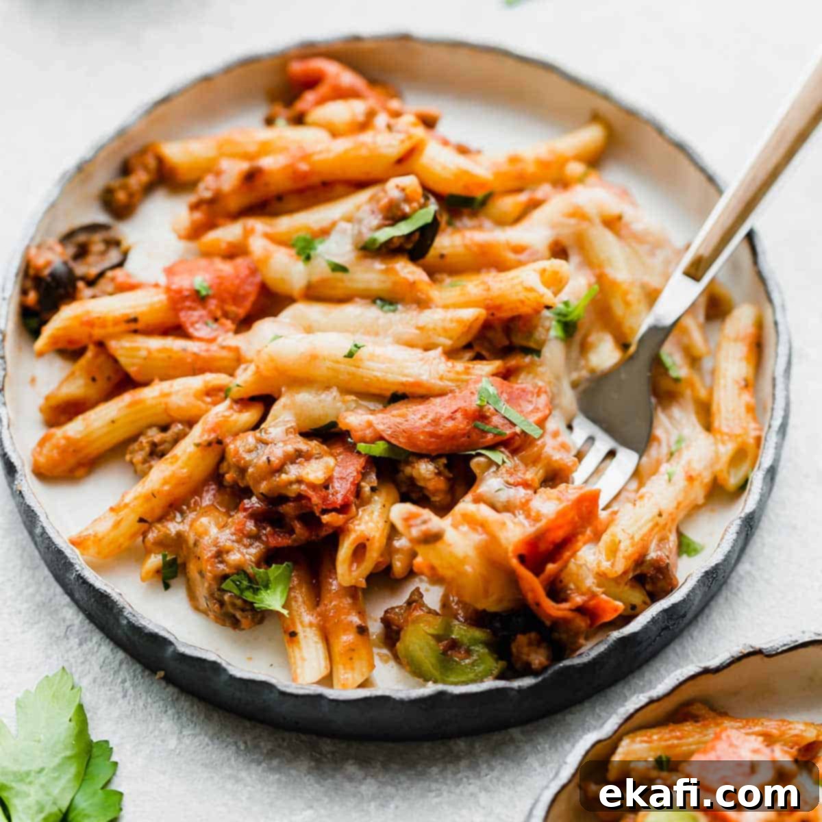 Happy Tummies Happy Kids 19 A slice of hearty pizza casserole, abundant with colorful peppers and savory pepperoni, presented on a white plate ready to be enjoyed.