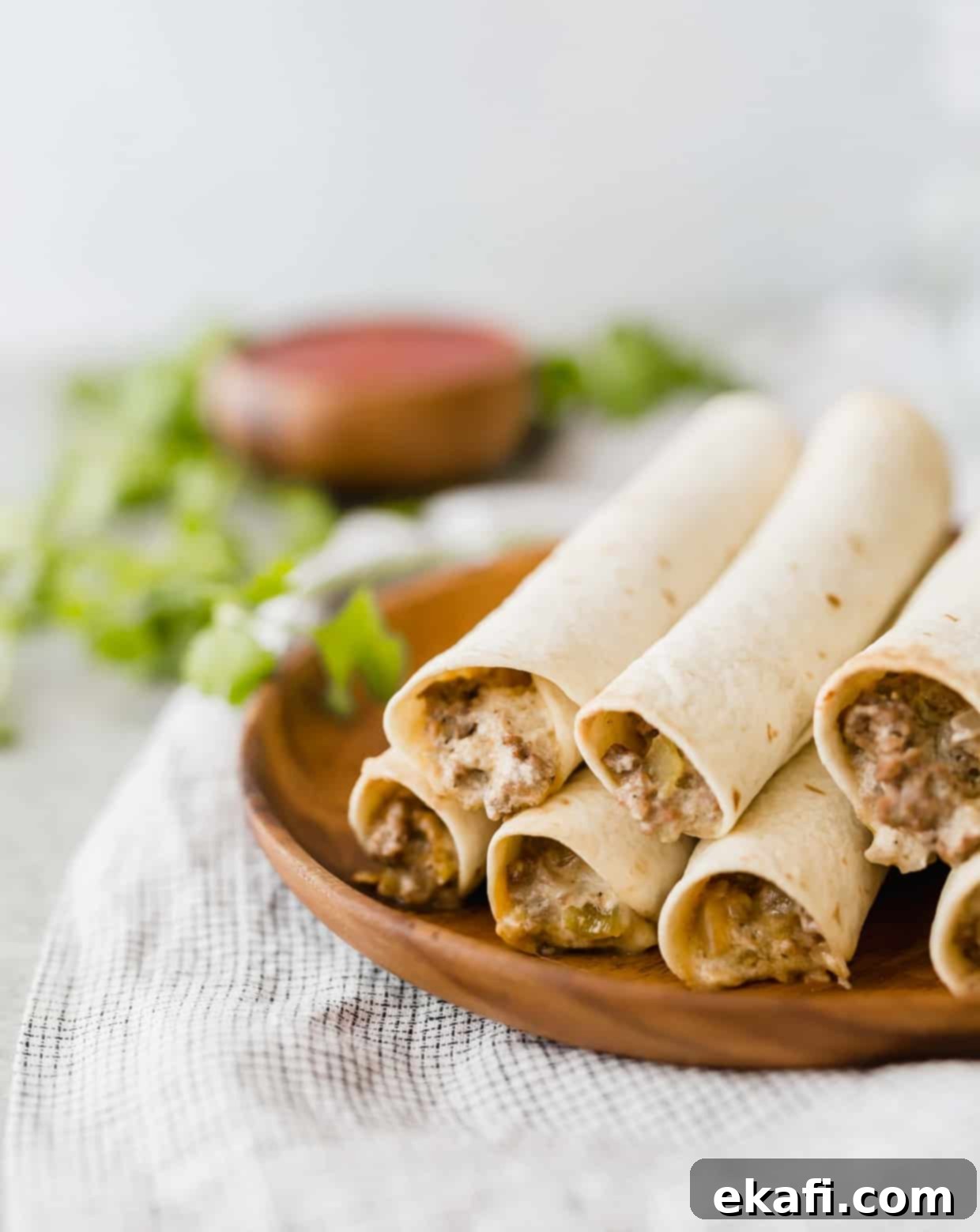 Happy Tummies Happy Kids 20 A perfectly stacked pile of crispy, golden-brown taquitos on a rustic brown plate, showcasing their inviting texture.