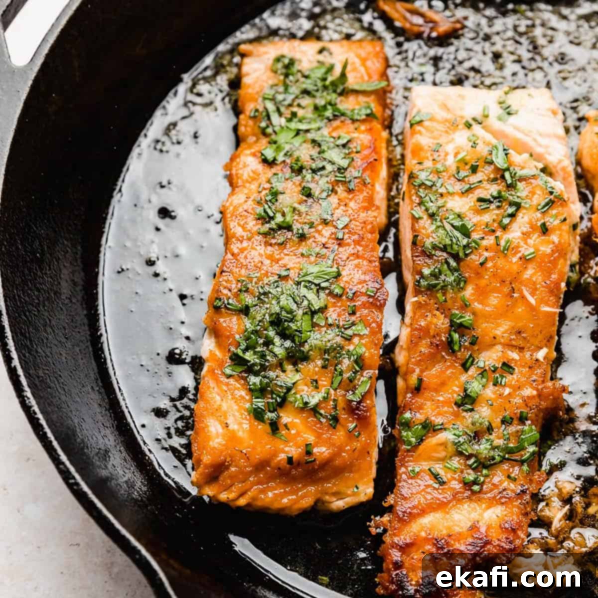 Happy Tummies Happy Kids 6 Perfectly seared Lemon Honey Glazed Salmon glistening in a black skillet, promising a flavorful and healthy meal.