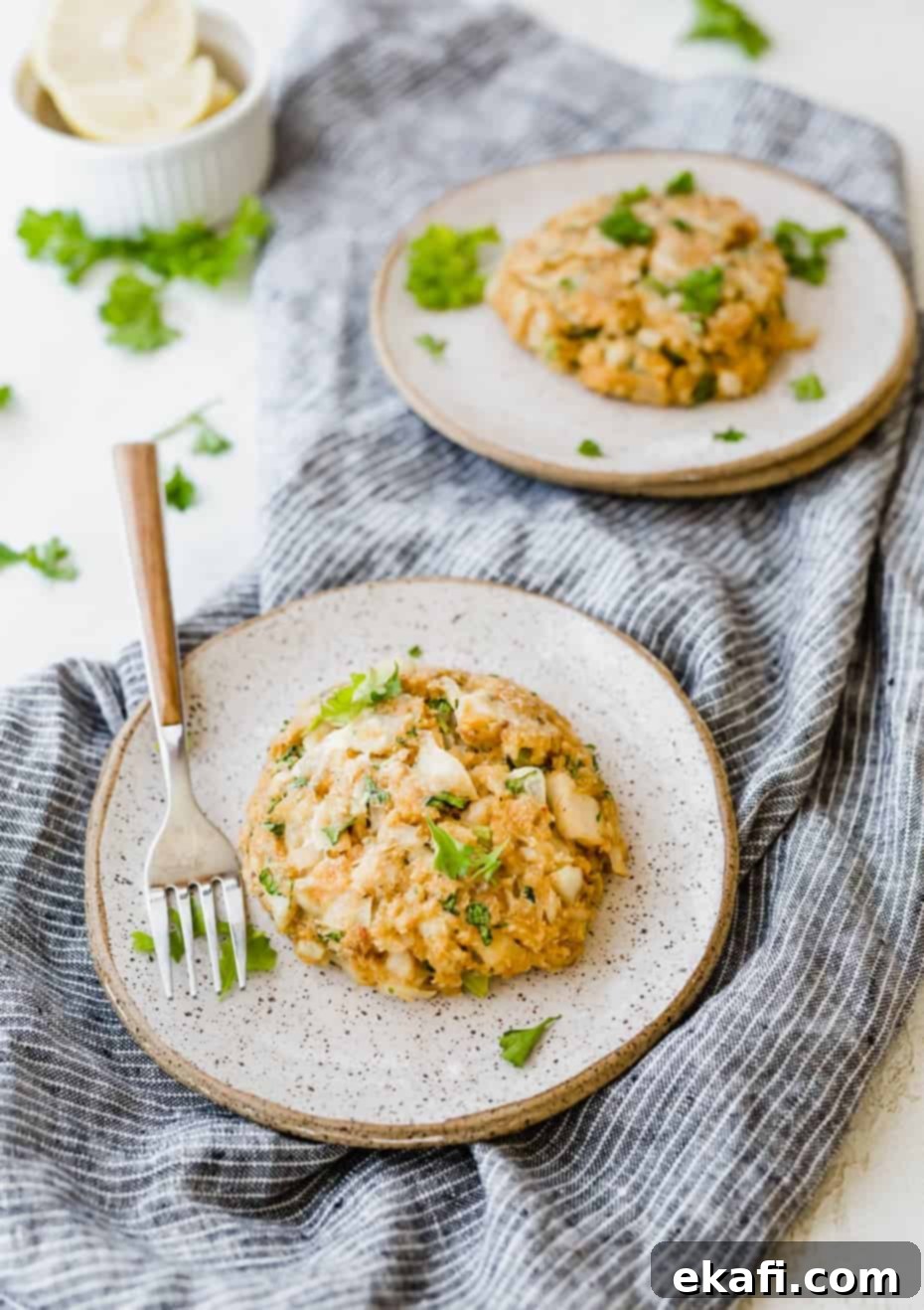 Happy Tummies Happy Kids 8 A perfectly golden-brown Tilapia Cake resting elegantly on a plate, set against a stylish blue linen napkin, highlighting its delicious texture.