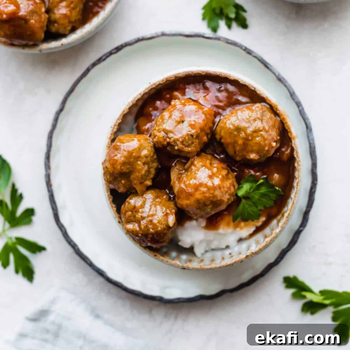 Happy Tummies Happy Kids 9 An inviting overhead photo of delicious crock pot BBQ Pineapple Meatballs, generously coated in sauce and presented in a bowl, ready to be devoured.