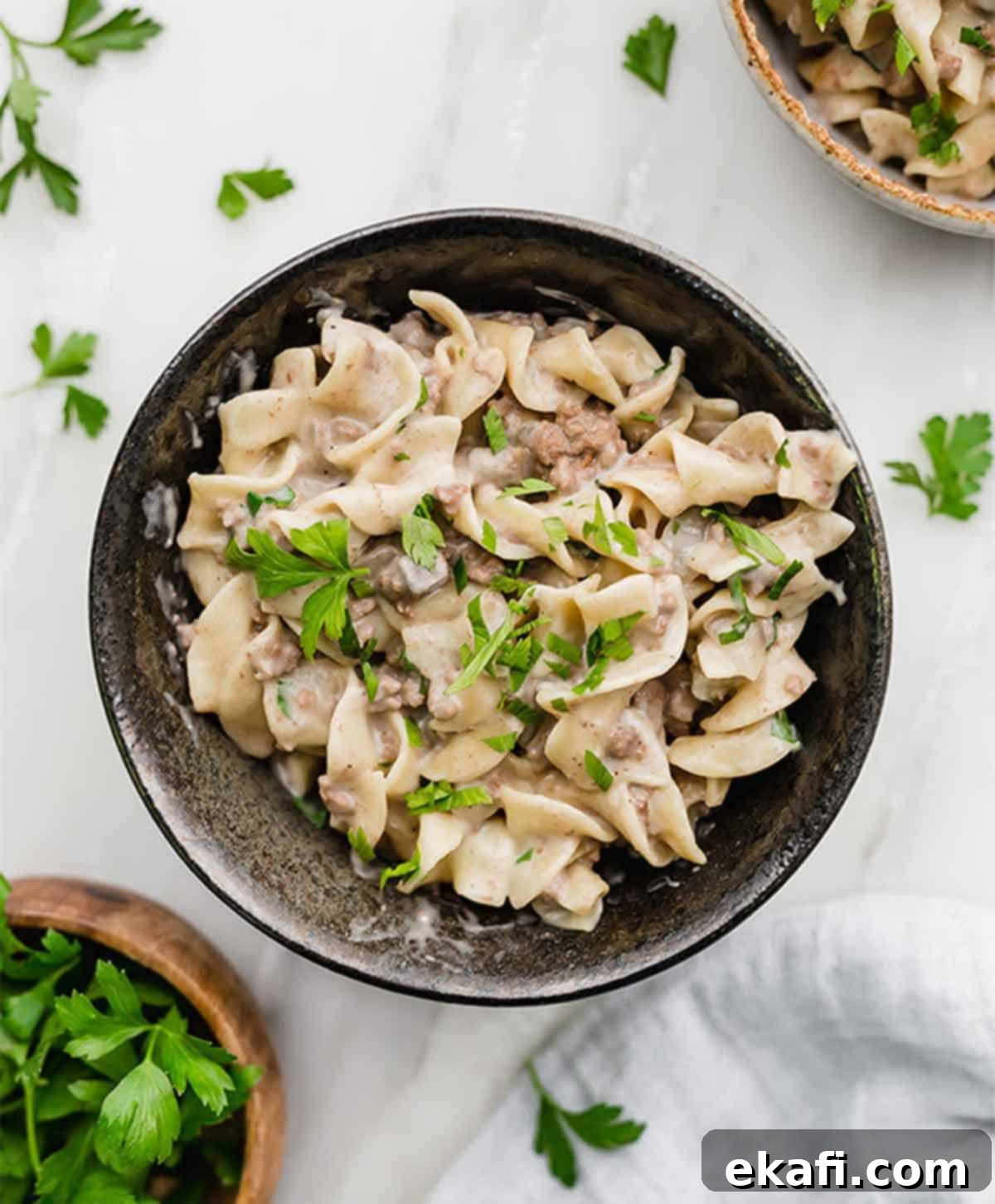 Instant Pot Ground Beef Stroganoff 6 A black bowl filled with creamy Instant Pot Beef Stroganoff, ready to be enjoyed.