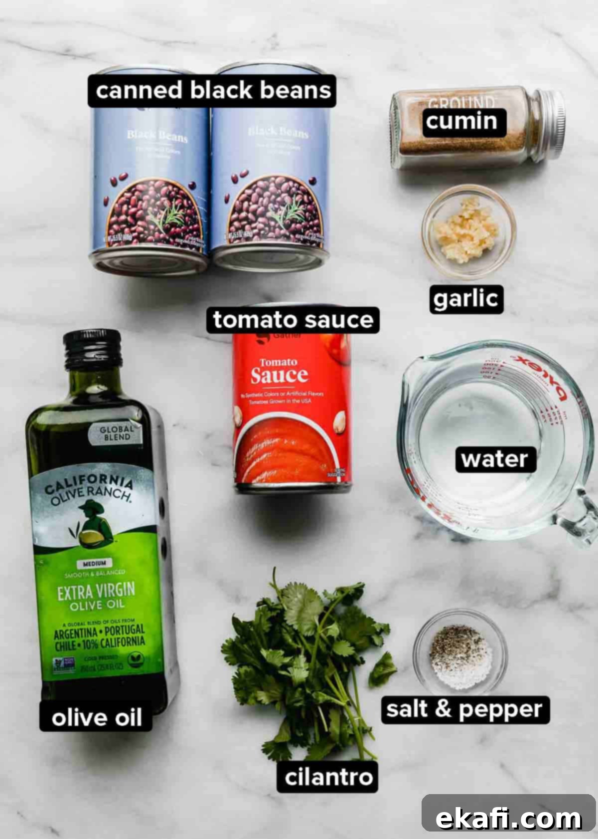 Cafe Rio Style Black Beans 3 Cafe Rio Black Beans ingredients laid out on a white marble background: black beans, tomato sauce, cilantro, seasonings, water, olive oil.