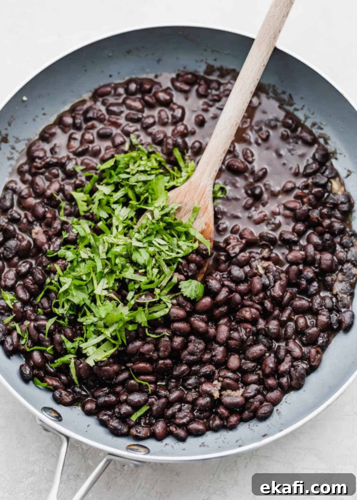 Cafe Rio Style Black Beans 5 Freshly chopped cilantro sprinkled on top of Cafe Rio black beans in a gray skillet.