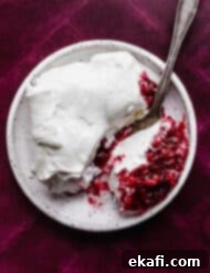 Ruby Pomegranate Delight 13 A slice of whipped topping covered Christmas Pomegranate Jell-O on a plum colored background.