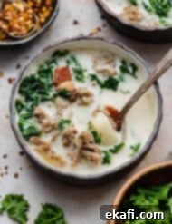Copycat Olive Garden Zuppa Toscana 6 A black bowl with copycat Olive Garden Zuppa Toscana Soup in it and a spoon.