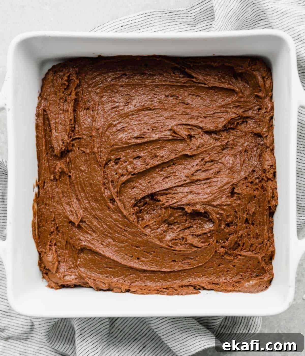 Κέικ με καυτή σοκολάτα 5 Ένα καφέ μείγμα Hot Fudge Cake σε ένα λευκό τετράγωνο ταψί.
