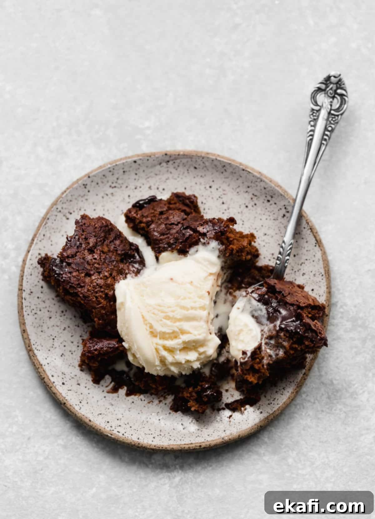 Κέικ με καυτή σοκολάτα 10 Φωτογραφία από πάνω Hot Fudge Cake σε πιάτο με μια μπάλα παγωτό βανίλιας.