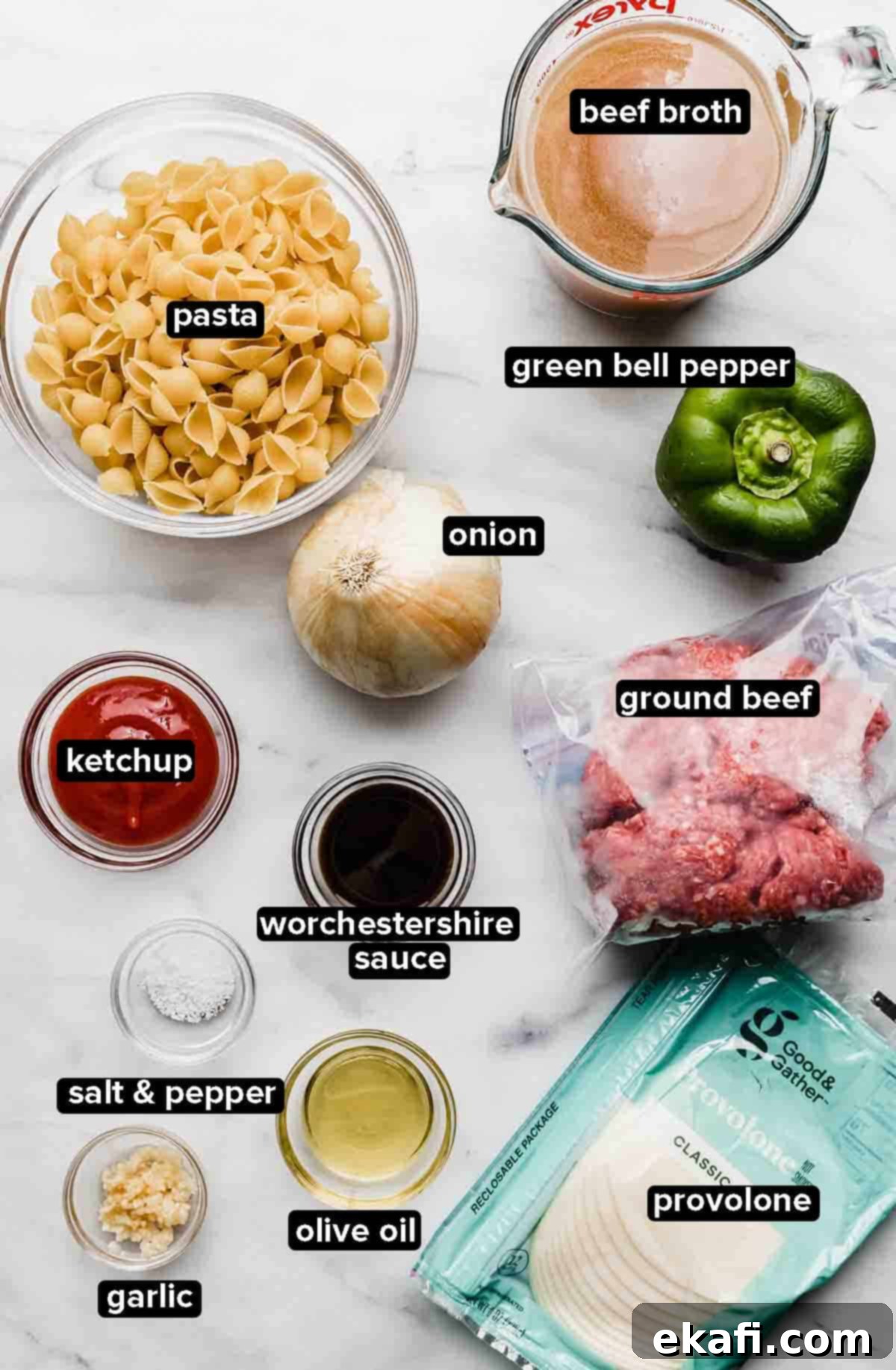 Creamy Instant Pot Philly Cheesesteak Pasta 3 Instant Pot Philly Cheesesteak Pasta ingredients laid out on a white marble background, including ground beef, bell peppers, onions, pasta, cheese, and sauces.