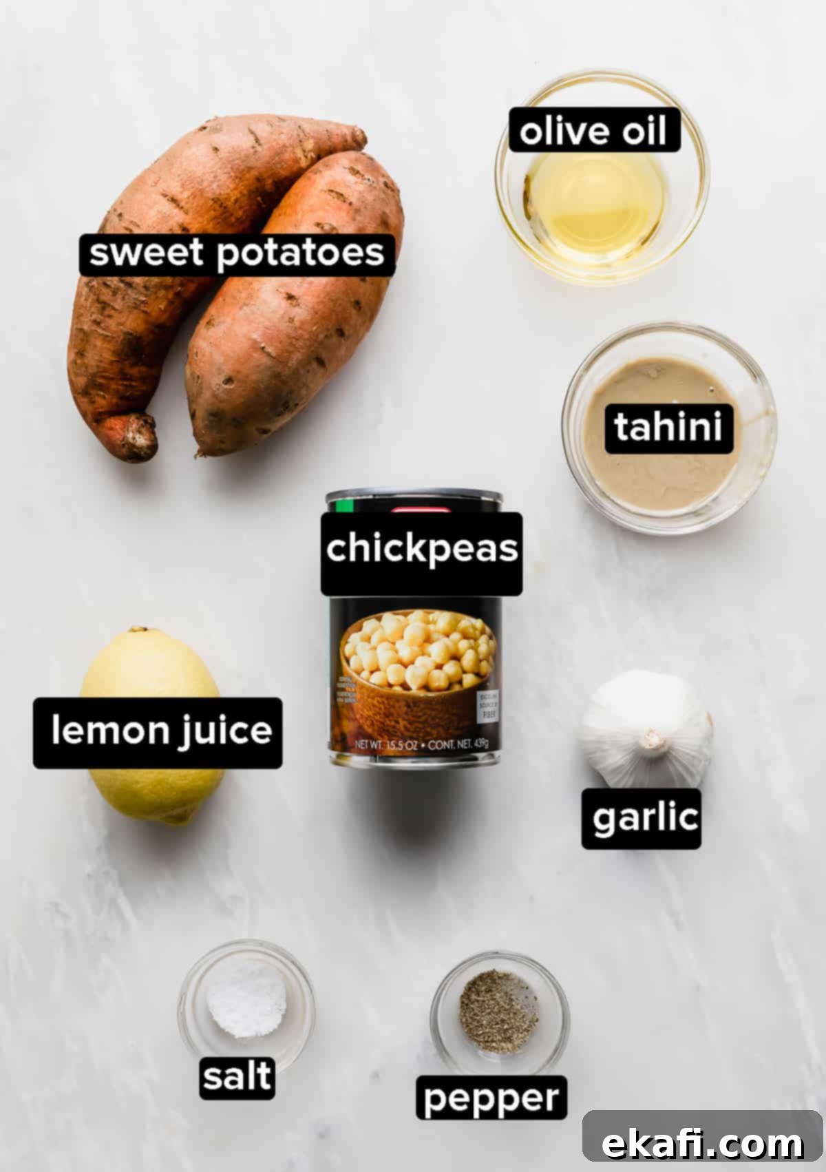 Sweet Potato Hummus 3 Sweet Potato Hummus ingredients laid out on a marble background, including sweet potatoes, chickpeas, tahini, and lemon.