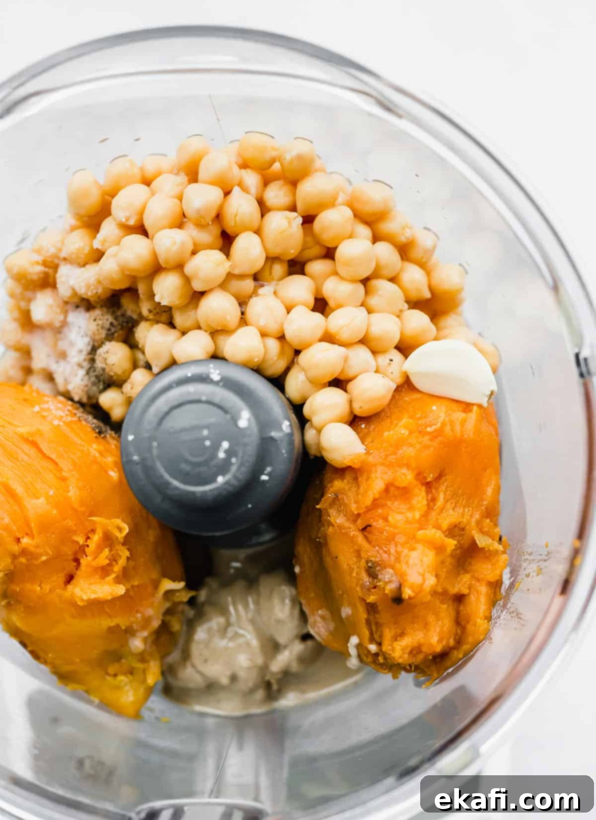 Sweet Potato Hummus 4 A food processor containing sweet potato, chickpeas, tahini, and other hummus ingredients before blending.