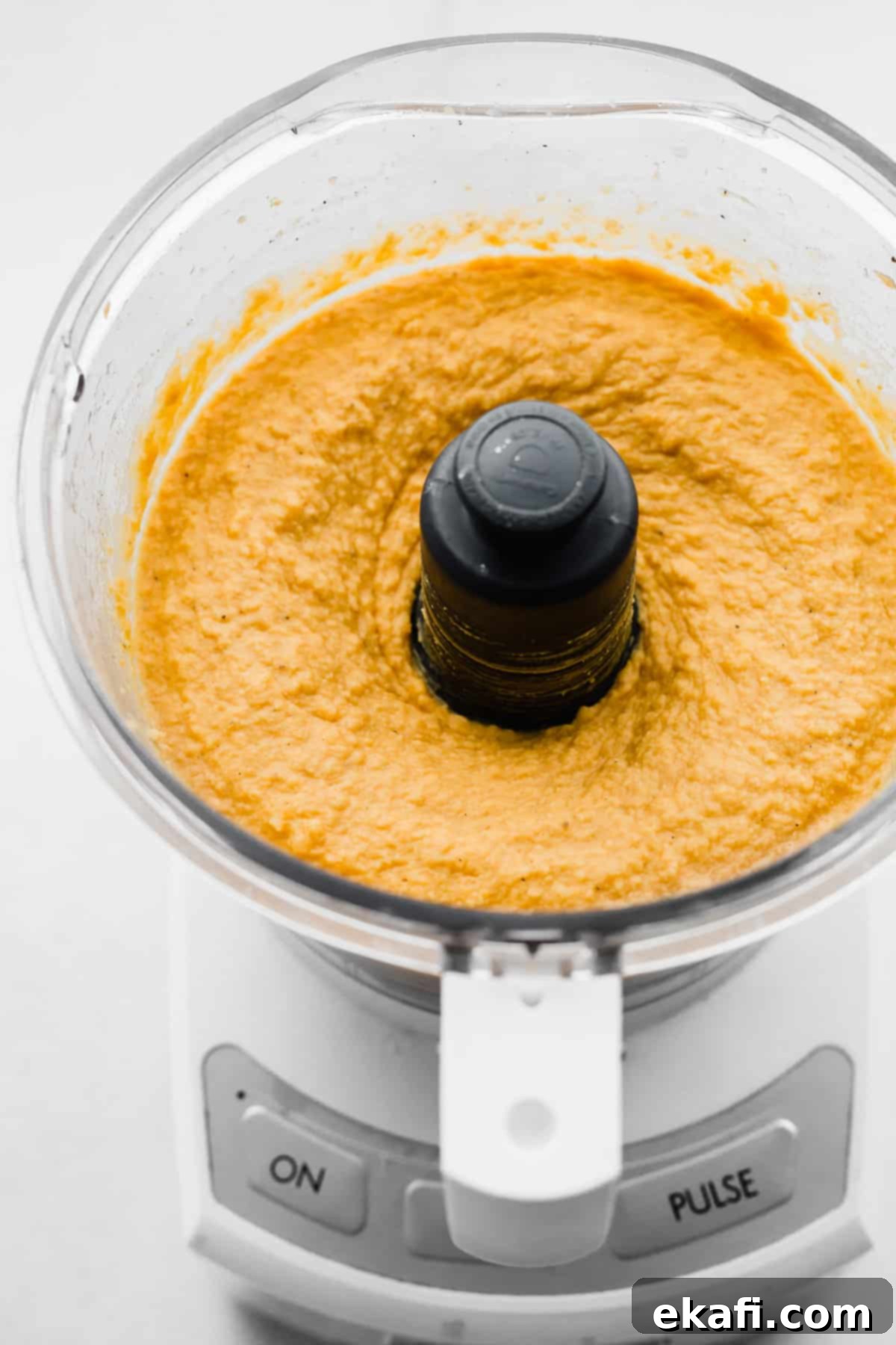 Sweet Potato Hummus 5 Pureed orange Sweet Potato Hummus swirling smoothly in a food processor, ready to be served.