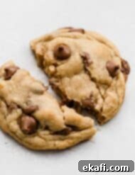 Copycat Crumbl Chocolate Chip Cookie Perfection 13 A delicious copycat Crumbl Chocolate Chip Cookie on a white background, highlighting its thick and soft texture.