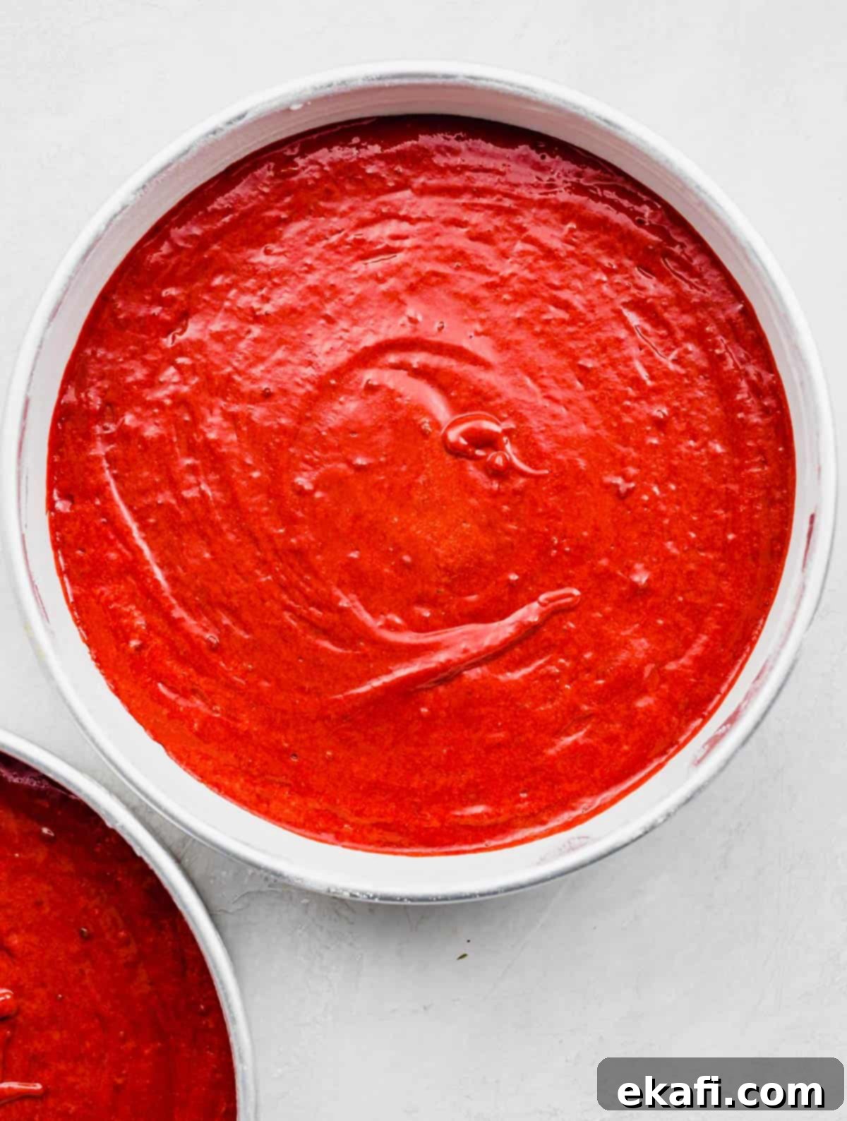 Heirloom Red Velvet Cake 6 A round, perfectly filled cake pan with raw red velvet cake batter, ready to be baked into delicious layers.
