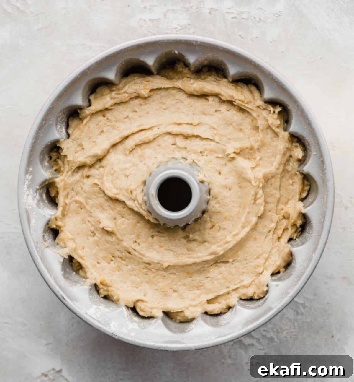 Vibrant Blood Orange Bundt Cake 5 A bundt cake pan filled with a light yellow colored Blood Orange Bundt Cake batter, ready for baking.