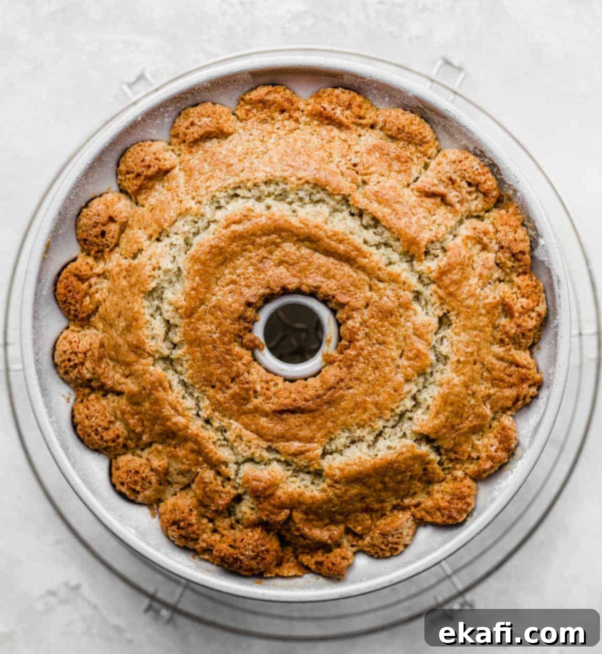 Vibrant Blood Orange Bundt Cake 6 A freshly baked blood orange cardamom bundt cake cooling in its bundt pan on a white background.