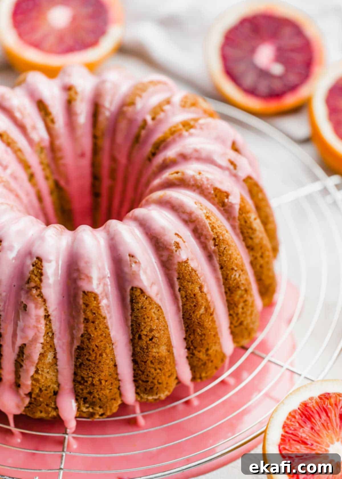 Vibrant Blood Orange Bundt Cake 10 Close-up of vibrant pink glaze cascading down the sides of a blood orange bundt cake, emphasizing its beauty and deliciousness.