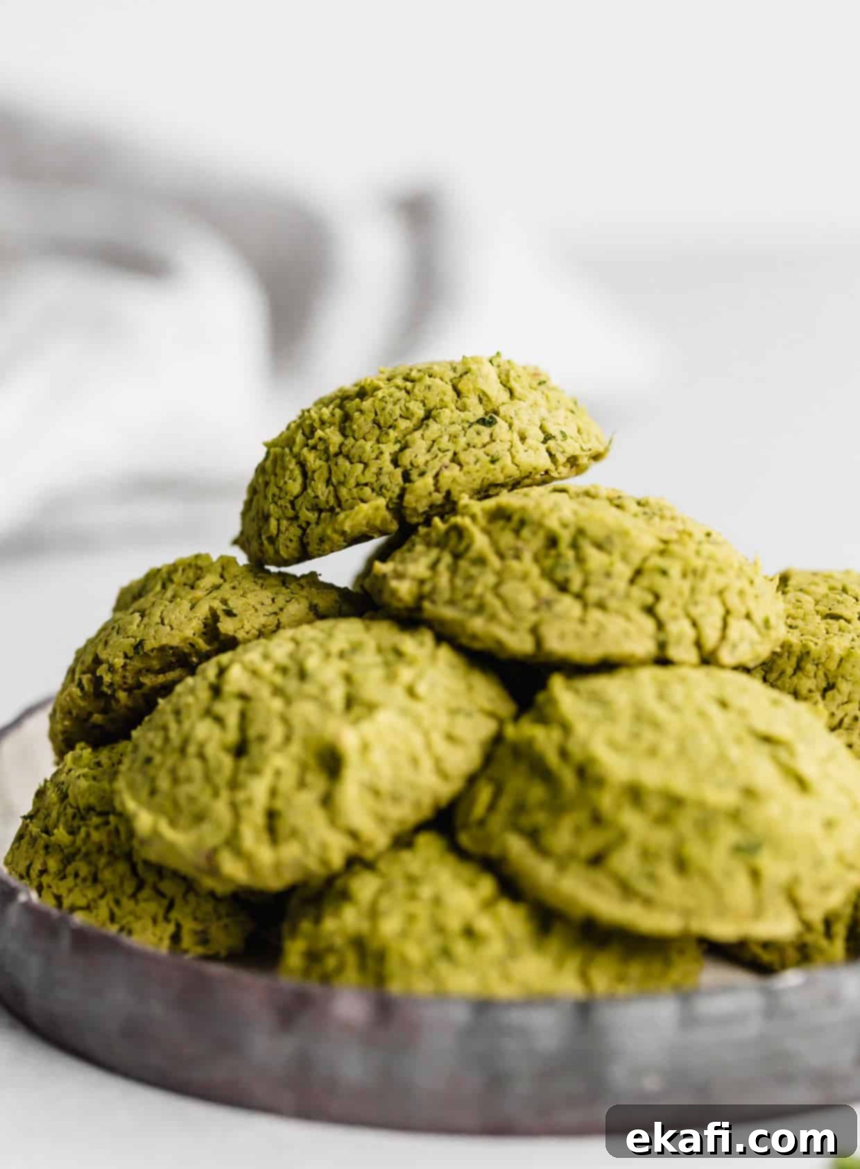 Fresh Herb Falafel 8 Baked Falafel on a black plate against a white background.