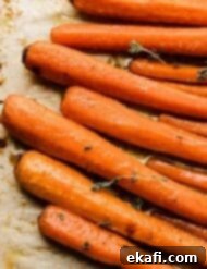 Καραμελωμένα Καρότα Καστανής Ζάχαρης 9 A close up photo of Brown Sugar Roasted Carrots on a tan parchment paper.