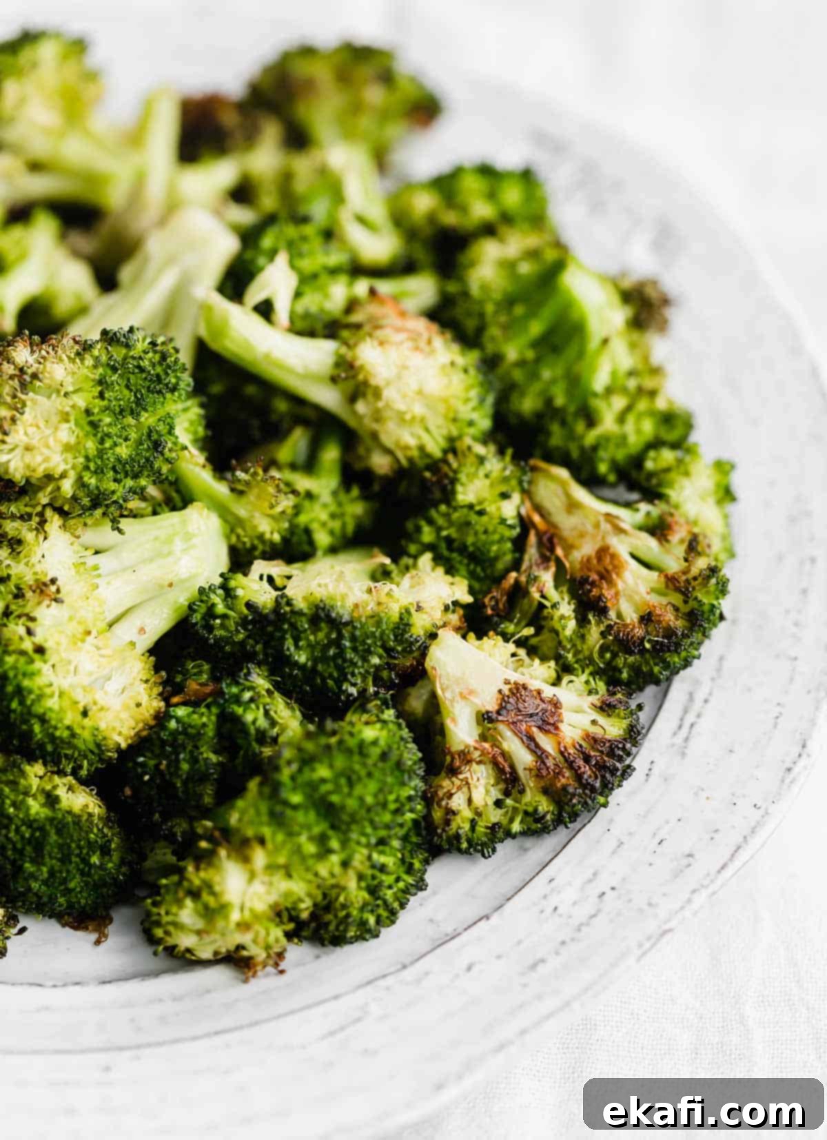 Crispy Oven Roasted Broccoli 6 Easy Oven Roasted Broccoli served on a pristine white plate, garnished and ready to enjoy.