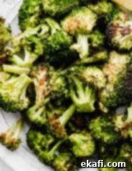 Crispy Oven Roasted Broccoli 7 Oven Roasted Broccoli on a white plate, ready to be served.