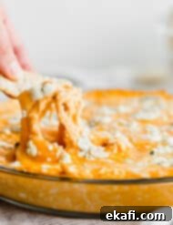 Ultimate Buffalo Chicken Dip 11 A tortilla chip dipping into buffalo chicken dip.