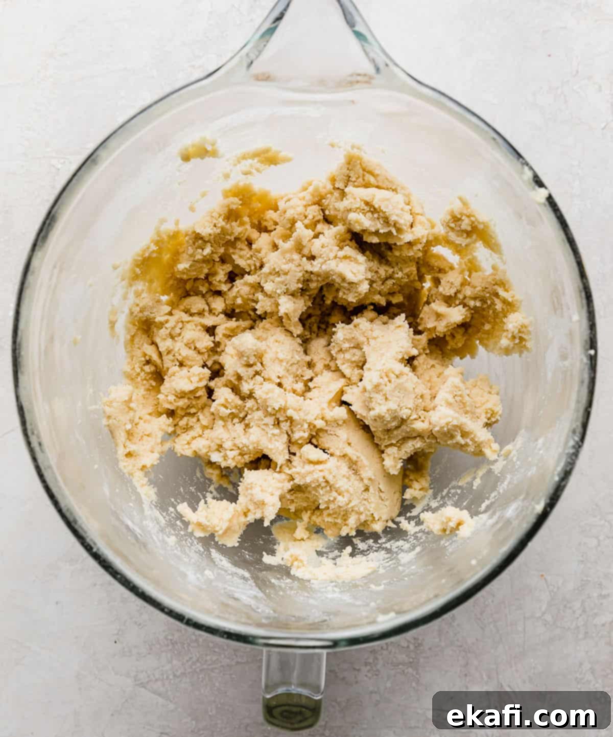 Sugared Delights 4 Freshly prepared sugar cookie dough in a single bowl, resting on a light gray background, ready for shaping.