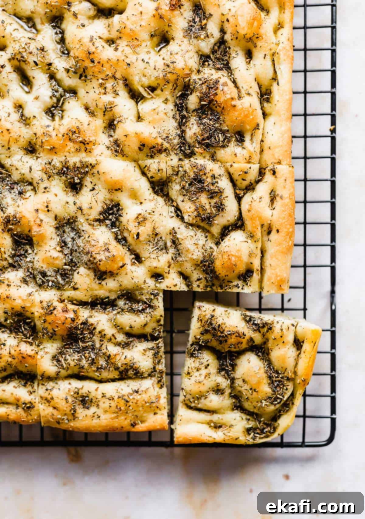 Artisanal Focaccia Bread 2 The best Focaccia Bread topped with herb oil on a black cooling rack.