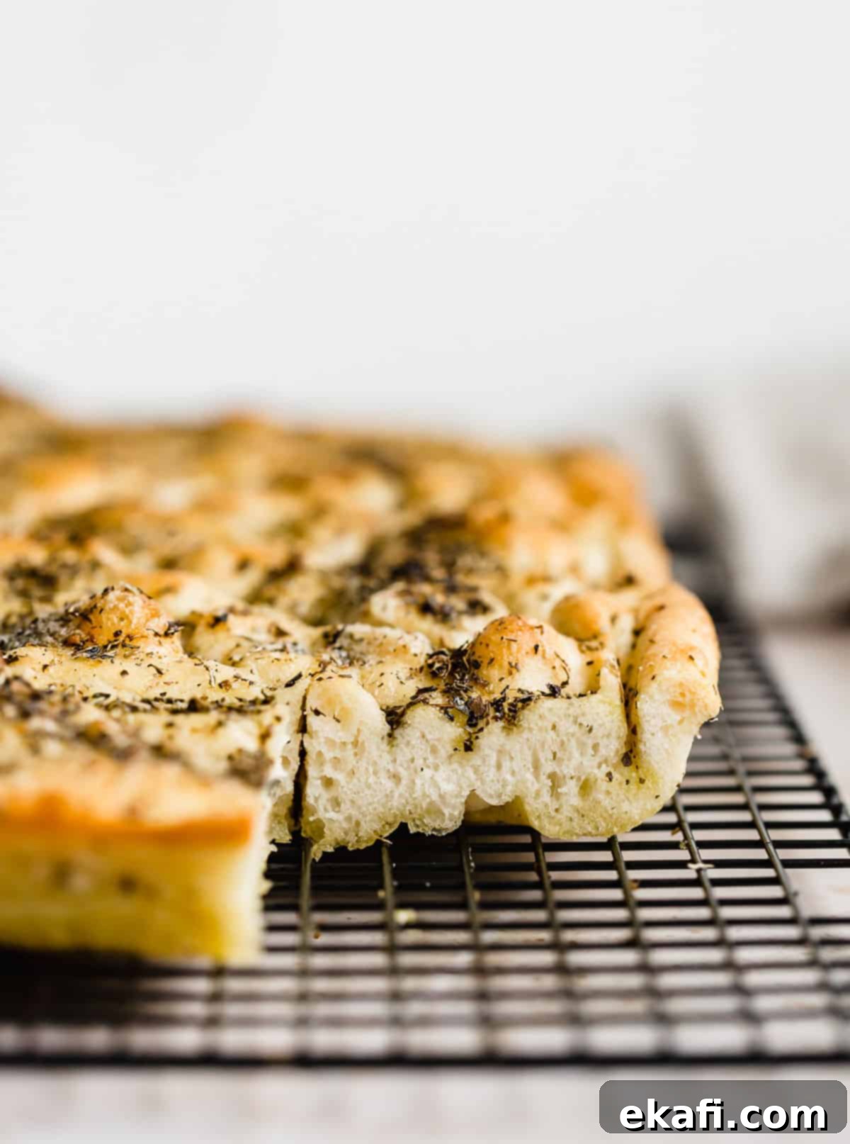 Artisanal Focaccia Bread 11 A side photo of a fluffy focaccia recipe showing the thick bread topped with herb olive oil.