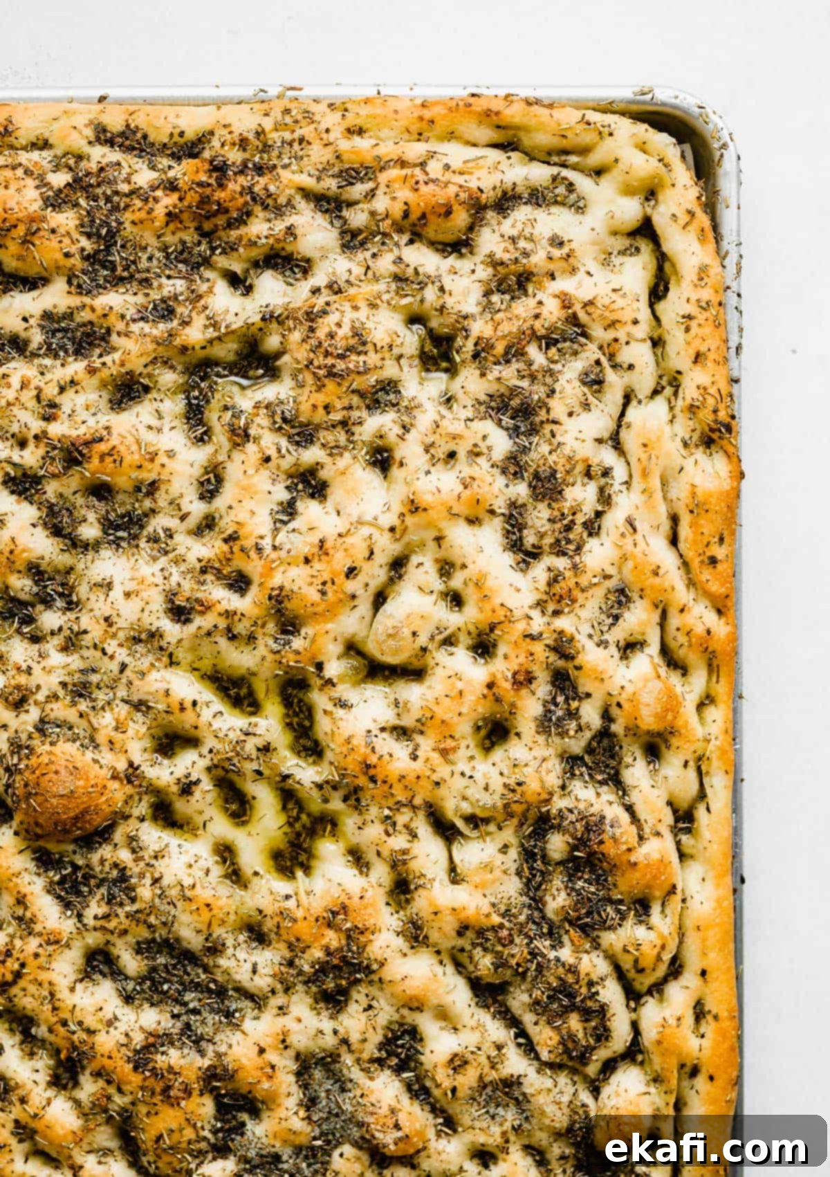 Artisanal Focaccia Bread 9 Easy Focaccia Bread in a baking sheet topped with lots of herbs, baked until golden brown on top.