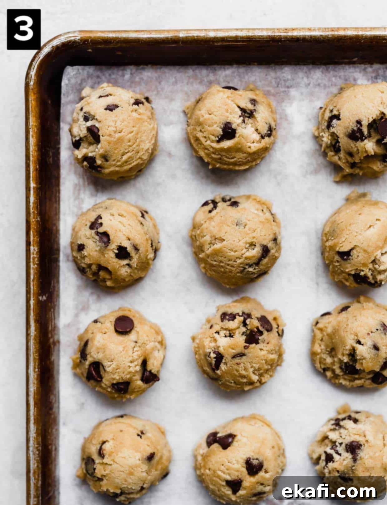 Sweet and Savory Tahini Chocolate Chip Cookies 5 Tahini Chocolate Chip Cookie dough balls on a baking sheet, ready for the oven.