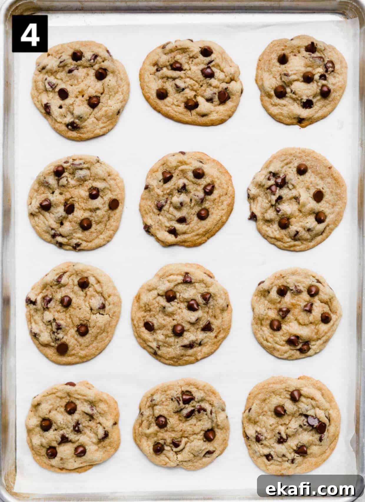 Sweet and Savory Tahini Chocolate Chip Cookies 6 Twelve baked Tahini Chocolate Chip Cookies on a white parchment lined baking sheet, sprinkled with sea salt.