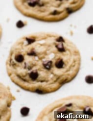Sweet and Savory Tahini Chocolate Chip Cookies 9 Sea salt topped Tahini Chocolate Chip Cookies on a white background.