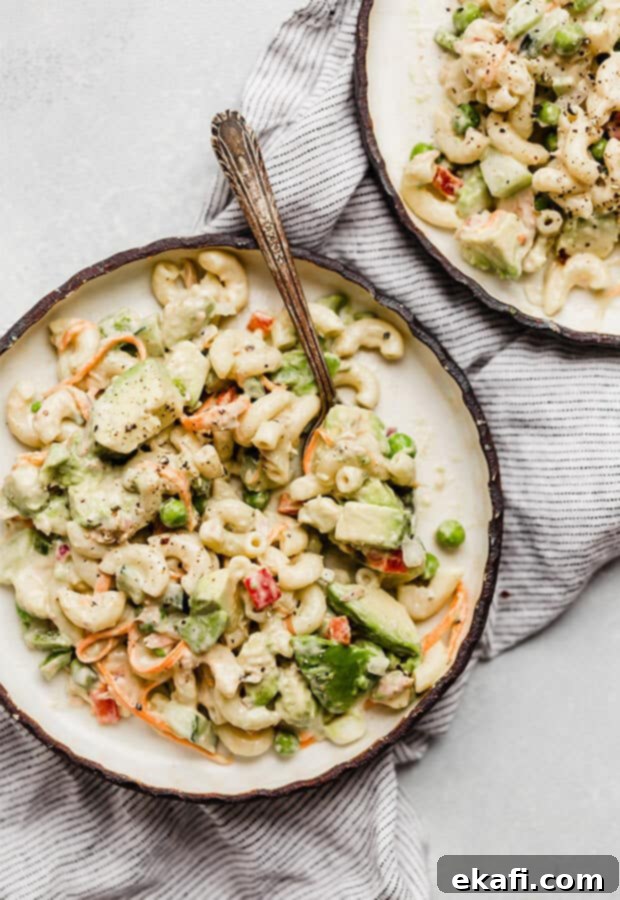 Creamy Tuna Avocado Macaroni Salad 2 A macaroni salad loaded with vegetables on a plate, featuring tuna and avocado.