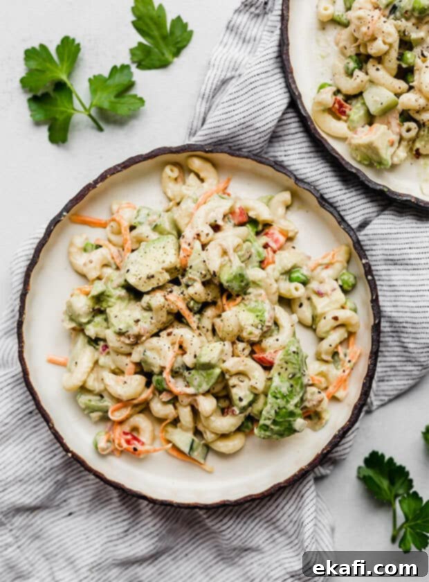 Creamy Tuna Avocado Macaroni Salad 8 A plate full of vibrant tuna macaroni salad with avocado and other fresh vegetables.