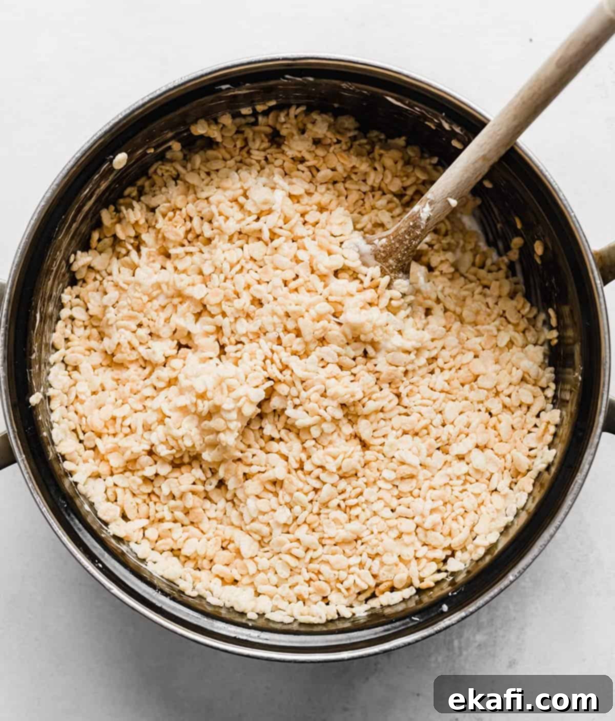 Ρυζοκροκέτες 5 Rice Krispy δημητριακά σε μια μαύρη κατσαρόλα, για να φτιάξετε κολλώδη Rice Krispies Treats.
