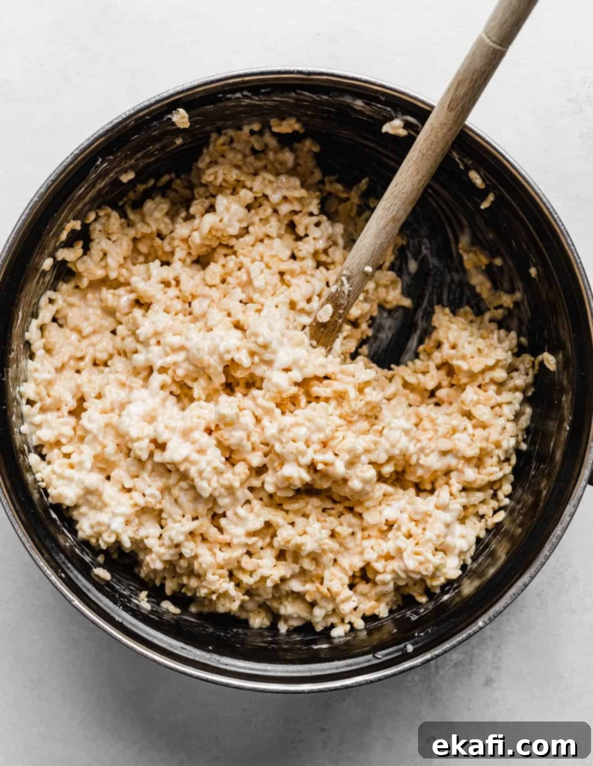 Ρυζοκροκέτες 6 Κολλώδη Rice Krispies Treats ανακατεύονται σε μια μεγάλη μαύρη κατσαρόλα.