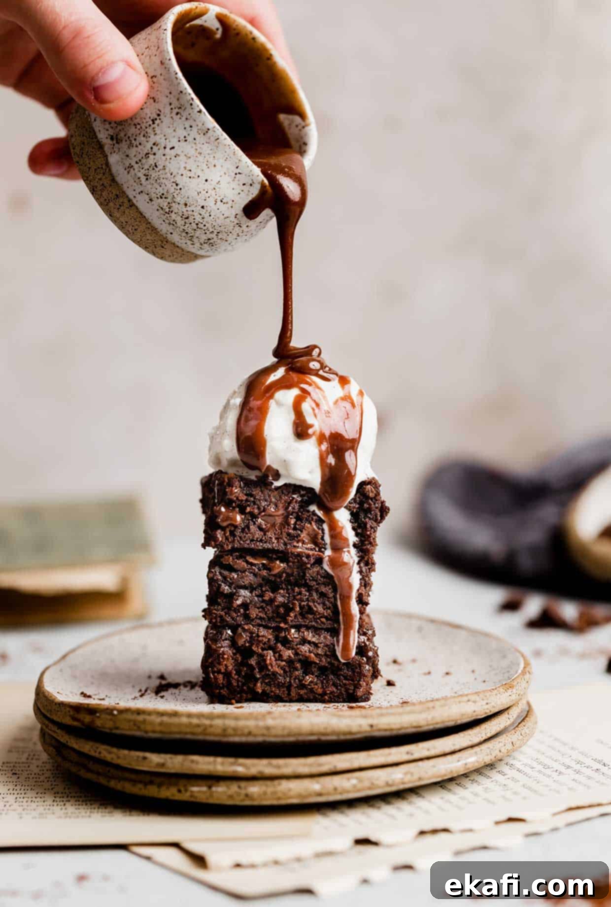 Fudgy Homemade Brownies 2 Two Homemade Fudgy Brownies stacked on top of each other, a scoop of vanilla ice cream on top, and hot fudge sauce drizzled over the ice cream.