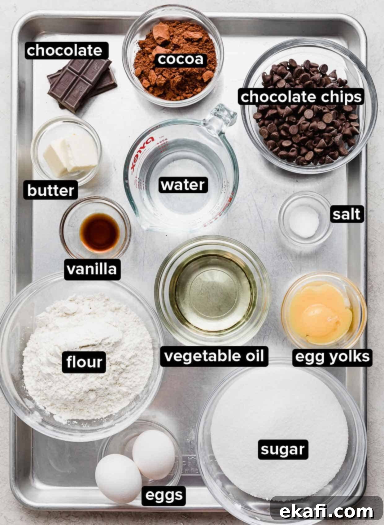 Fudgy Homemade Brownies 3 Homemade brownie ingredients portioned into glass bowls on a silver baking tray.