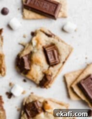 Smores Cookies 8 A stack of S'mores Cookies, showcasing their golden-brown edges, melted chocolate, and gooey marshmallows.