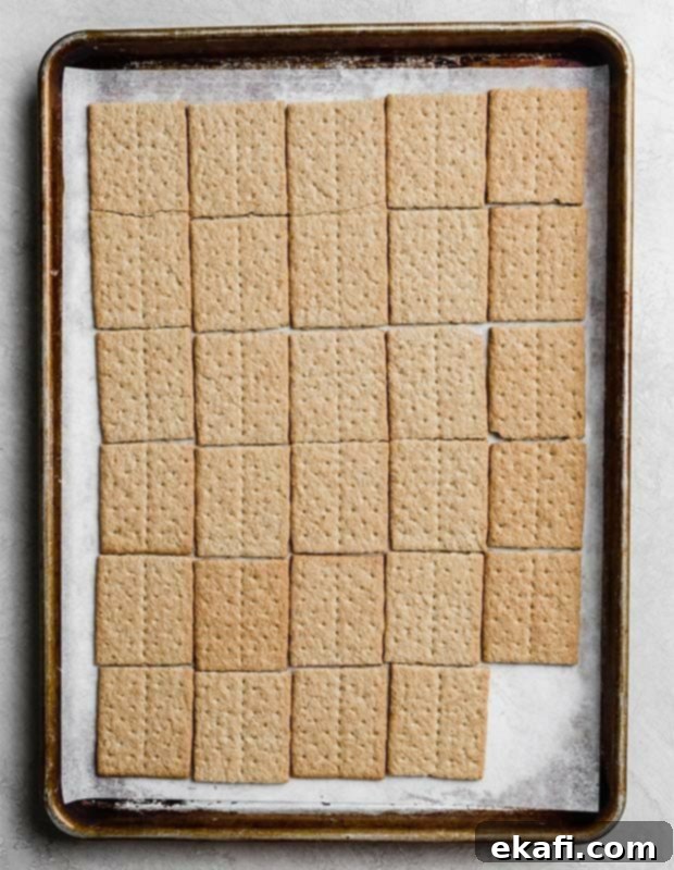 Smores Cookies 5 A baking sheet lined with parchment paper, perfectly covered with graham cracker squares laid out, ready for the cookie dough.