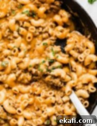 Homemade Cheesy Beef Pasta Skillet 10 A close up photo of macaroni noodles, ground beef, and a cheesy sauce in a cast iron skillet.